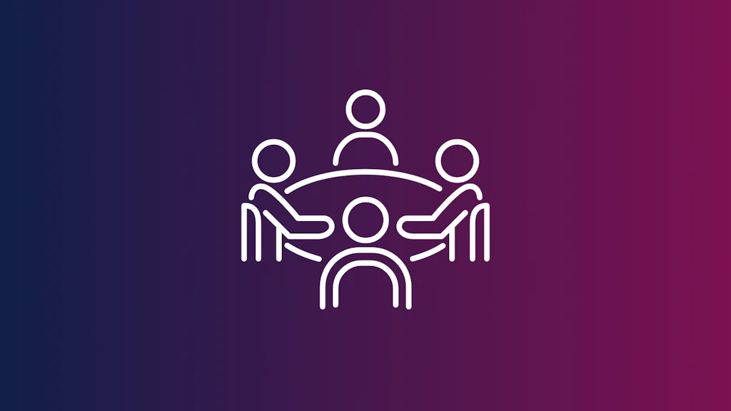 Symbolbild für ein Gremium - vier Personen sitzen an einem Tisch